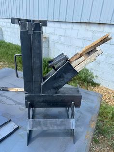 a metal object sitting on top of a cement slab in front of a brick building