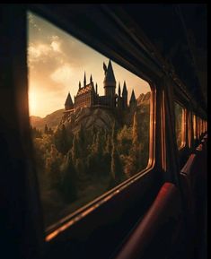 a castle seen through the window of a train at sunset or sunrise, with trees and mountains in the background