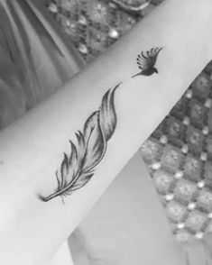 a woman's arm with a feather tattoo on it