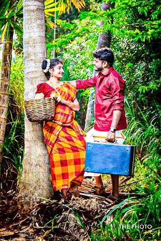 a man and woman standing next to each other in the woods with luggage on their back