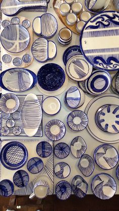 a table topped with lots of blue and white plates