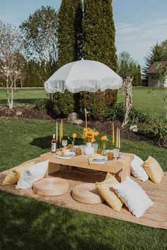 a picnic table with an umbrella and pillows