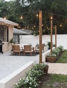 an outdoor patio with lights strung over it and seating area next to the bbq