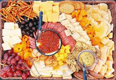 a platter filled with cheese, crackers and fruit