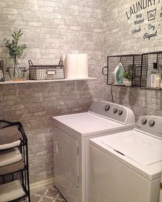 a washer and dryer in a laundry room with brick walls, shelves on the wall