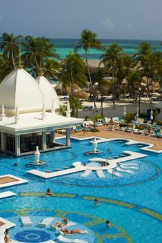 an outdoor swimming pool surrounded by palm trees