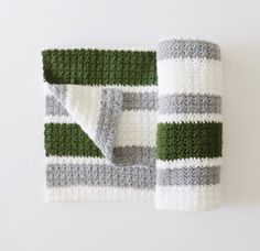 a green and white striped blanket laying on top of a table