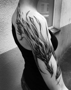 black and white photo of a woman's arm with branches tattoo on her left arm