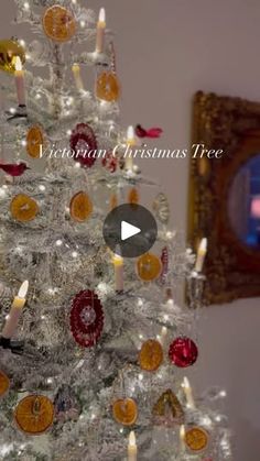 a white christmas tree decorated with ornaments and candles