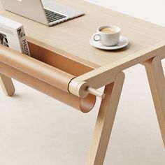 a wooden table with a laptop on it and a cup of coffee next to it