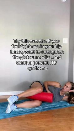 a woman laying on top of a blue mat in front of a wall with a quote