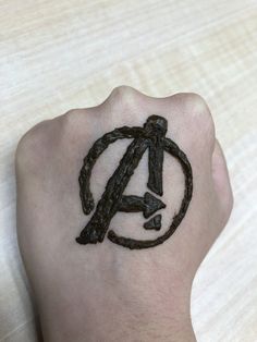 a person's hand with a tattoo on it that has the letter a in black ink