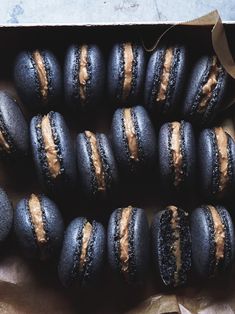 there are many blue and brown macaroons on the table