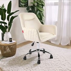 a white office chair sitting on top of a rug next to a potted plant