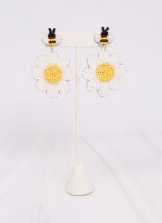 This beautiful beaded earring is Spring ready! It features a daisy flower and an adorable bee post. It is also felt covered on the back. Dimensions: 2.75" long White Dangle Flower Earrings For Spring, White Daisy Flower Earrings For Spring, Adjustable White Flower Earrings For Spring, White Beaded Adjustable Flower Earrings, Handmade Daisy White Earrings, White Flower Beaded Earrings For Spring, Handmade White Daisy Earrings, Handmade White Beaded Flower-shaped Earrings, Handmade White Beaded Flower Earrings