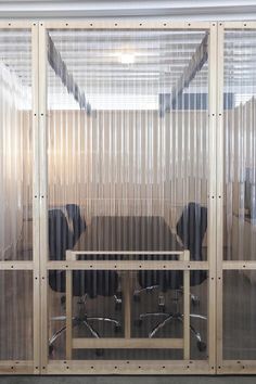 an empty conference room with glass walls and black chairs