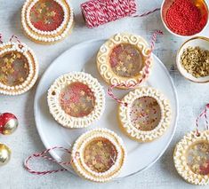 some cookies are on a white plate with red and gold decorations next to other items