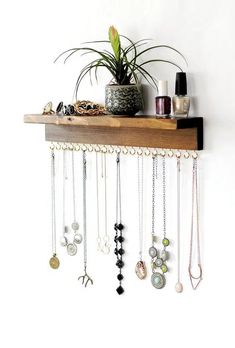 a wooden shelf filled with lots of necklaces and jewelry hanging from it's sides