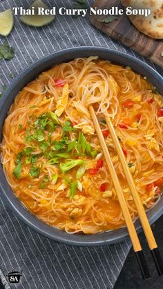 thai noodle soup in a bowl with chopsticks and bread on the side