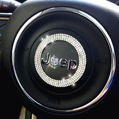 the steering wheel cover is adorned with swaroons and beads, which spell out jeep