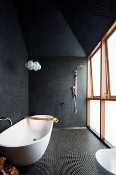 a white bath tub sitting in a bathroom next to a shower head and faucet