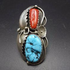 "VINTAGE NAVAJO RING DESCRIPTION: This gorgeous ring features lovely specimens of old red Mediterranean coral and brilliant blue Sleeping Beauty turquoise. The gemstones are secure in scalloped bezel, on a foundation of heavy gauge vintage sterling silver. Applied leaves and flower provide bold accent for the cabochons. This ring will be a treasured addition to your collection of fine vintage Native American jewelry. MEASUREMENTS: Ring face measures 2 1/4\" x 1 1/8\" Turquoise cabochon measures Red Inlay Ring, Red Inlay Ring Jewelry, Red Ring With Inlay, Collectible Red Gemstone Rings, Red Sterling Silver Ring With Inlay, Red Sterling Silver Rings With Inlay, Vintage Red Gemstone Jewelry, Red Heirloom Jewelry For Collectors, Collectible Oval Red Ring