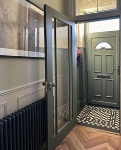 an entry way with a green door and black and white checkerboard flooring