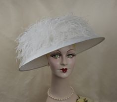 Ooh, la la!  Masses of frothy feathers adorn this elegant showstopper.  Light and airy, this fashionable ladies hat has a very wide brim and is a lovely white shade, ideal for a wedding or special event - a soft yet dramatic feminine look!   This hat is handmade and hand-blocked in white, parasisal straw.  Very full and fluffy ostrich feathers surround the crown creating a distinctive and unexpected silhouette. Style - White Parfait Brim measures 5 inches. May be made to order in your hat size, Evening Mini Hat With Feather Trim And Curved Brim, Kentucky Derby Mini Hat With Feather Trim, Evening Top Hat With Feathers And Short Brim, Feathered Top Hat For Church, Evening Mini Hat With Curved Brim And Feathers, Elegant Summer Fascinator With Feather Trim, Chic Evening Mini Hats With Feathers, Top Hat With Feather Trim For Royal Ascot Evening, Feather Trim Top Hat For Royal Ascot Evening