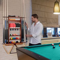 a man is playing pool in an indoor game room with billiards and balls