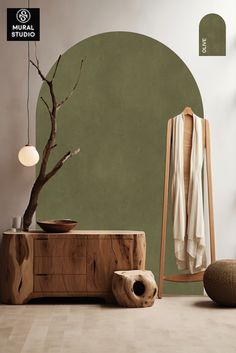 a room with green walls and a tree in the corner, next to a chair