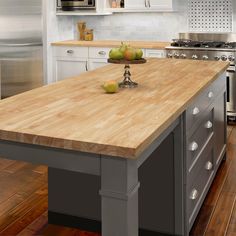 a kitchen island with two apples on it and an oven in the backround