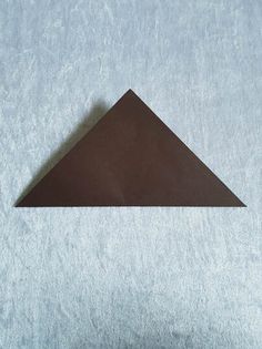 a brown triangle sitting on top of a white surface