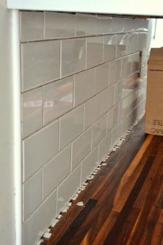 a box sitting on top of a hard wood floor next to a white brick wall