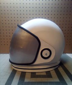 a white helmet sitting on top of a tiled floor