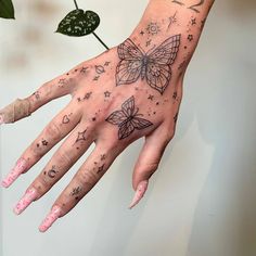 a woman's hand with tattoos on it and a butterfly tattoo on the palm