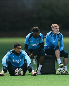 three soccer players sitting on the ground