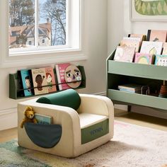 a child's room with bookshelves and toys on the floor in front of a window