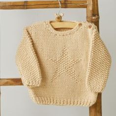 a knitted sweater hanging on a wooden chair next to a string and clothes peg