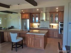 a large kitchen with wooden cabinets and stainless steel appliances, along with a breakfast bar