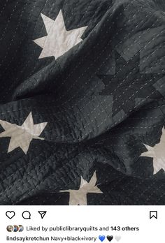 an american flag quilted with white stars on black and grey background, closeup