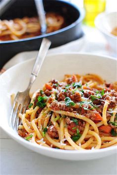 a white bowl filled with pasta and meat