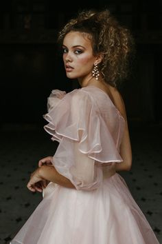 a woman in a pink dress posing for the camera