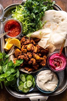 a tray filled with different types of food and dipping sauces on top of it