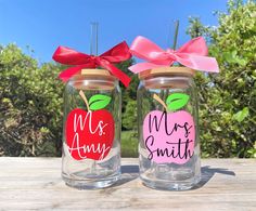 two mason jars decorated with apple and mr and mrs smith on the lids, tied with red ribbon