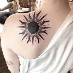 a woman with a sun tattoo on her shoulder