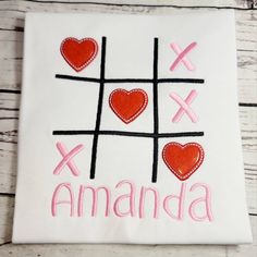 a white t - shirt with red hearts on it and the word amanda written in pink