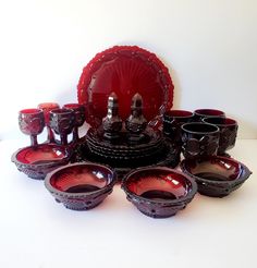 a table topped with red dishes and cups