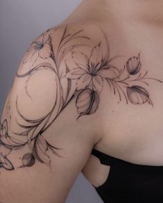 a woman's shoulder with flowers and leaves on the top half of her body