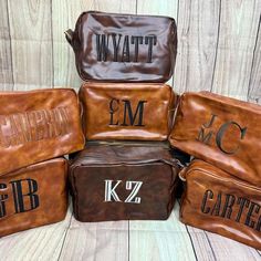 five brown leather bags with the names of four different brands on them, all stacked up together