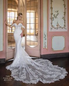 a woman in a white wedding dress standing next to an open doorway with pink walls